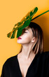 © Masson - Beautiful woman in dark clothes with palm leaf