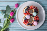 Fototapeta  - Cake in shape of number 8 decorated with berries and flowers tulips. Dessert for women's day on the eighth of March