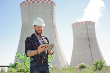 Wall Mural - Smiling engineer using a tablet in a facility