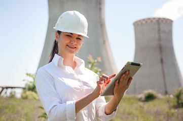 Wall Mural - Smiling engineer woman with tablet on electric station