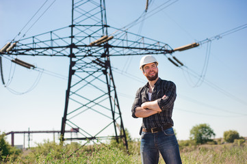 Wall Mural - Engineer with white hard hat under the power lines.Engineer work at an electrical substation.