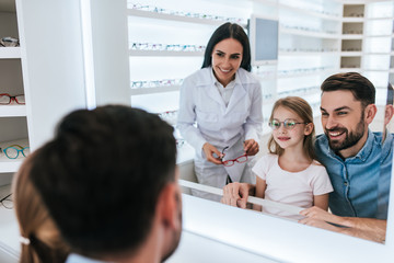 Wall Mural - Dad with daughter in ophthalmology clinic