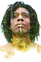 Double exposure Portrait of a Sexy African man with traditional face paint and determined expression combined with lush tropical leaves