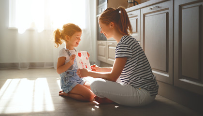 Wall Mural - happy mother's day! child daughter congratulates her mother and  read postcard.