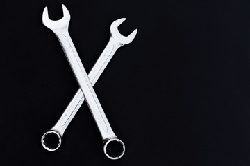 Two steel wrench on black background. Concept of men's power.