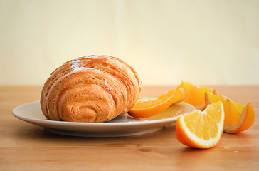 Wall Mural - Plate with tasty croissant and orange slices on table