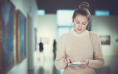 Wall Mural - Woman with guide looking at pictures in museum