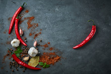 Food Cooking Background With Chili Peppers, Garlic And Spices On Dark Stone Table.
