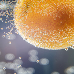 A close-up shot of citrus in a glass of water with lots of bubbles beautiful background for greeting cards and advertising materials.