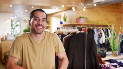 Wall Mural - Smiling Hispanic man walks into focus in a clothes shop