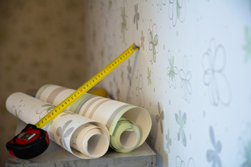 Two rolls of wallpaper and a measuring tape