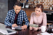 © LIGHTFIELD STUDIOS - portrait of couple counting money while sitting at table at home