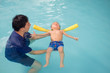 © yAOinLoVE - Asian Father take Cute little Asian 18 months / 1 year old toddler baby boy child to swimming class in Thailand, kid learn to float with pool noodle with dad at indoor pool, Shallow depth of field