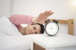 © NaMong Productions - Man wake up doing turn off alarm clock in the morning. He tired and lazy do work.