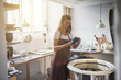 © Flamingo Images - Female artisan inspected glazed pottery in her creative workshop