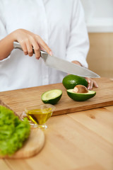 Wall Mural - Diet. Female Hands Cutting Avocado In Kitchen.