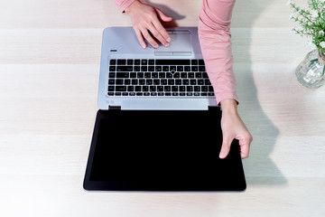 woman using laptop, searching, checking, browsing information on the wooden table