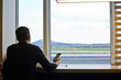 © Ксения Ощепкова - A man with a smartphone waiting for the plane, flight at the airport