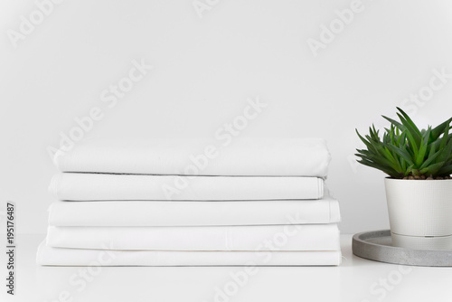 Fotografía A stack of fabrics over white table background