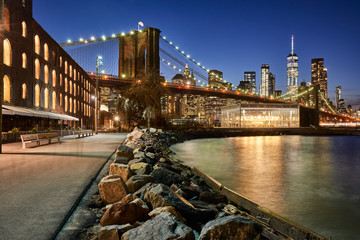 Fototapete - Brooklyn Bridge Park riverfront at twilight with view on the skyscrapers of Lower Manhattan and the Brooklyn Bridge. Brooklyn, Manhattan, New York City