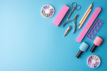 A Set Of Cosmetic Tools For Manicure And Pedicure On A Blue Background. Gel Polishes, Nail Files And Clippers, Top View