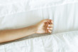 © blackday - Lonely female hand on the soft bed linen