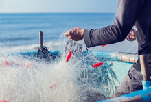 Fisherman On Boat With Net In Hands