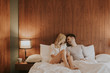 © BGStock72 - Young adult heterosexual couple on bed in bedroom