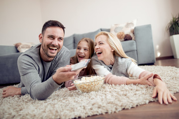 Wall Mural - Family lying on the floor watching TV together.