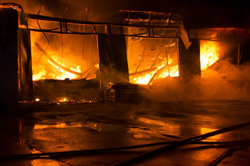 a garage on fire with flames coming thought the roof