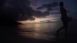 Frau geht bei Sonnenuntergang am Strand spazieren (Seychellen)