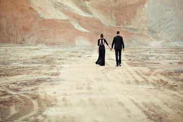 The bride and groom dressed in black are leaving