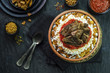 Arabic cuisine, Egyptian oriental Fettah with white rice and crispy bread topped with seasoned garlic red sauce,crispy fried garlic and veal chunks on rustic dark background.Top view,close-up