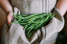 Woman Holding Green Beans In Her Apron
