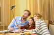 © DenisProduction.com - Family taking a funny selfie. Parents with daughter, dinner.