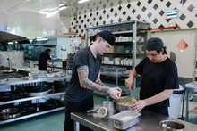 Chef And  Cook Apprentice Working Together In A Catering Kitchen