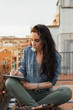 © Milles Studio/Stocksy - Woman with notepad on rooftop