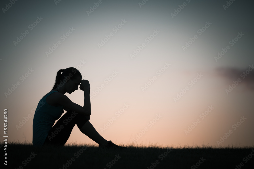 Silhouette of woman sitting alone feeling sad and stressed. Stock Photo ...