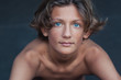 © Cindy Prins/Stocksy - Bare chested blue-eyed teen portrait in summer