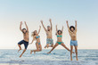 © victortorres/Stocksy - Multi-ethnic friends jumping and having fun at the beach