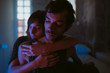 © Thais Ramos Varela/Stocksy - young couple hugging in a blue iluminated bedroom