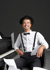 Sticker - Young man sitting near piano with flying music sheets indoors