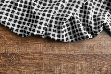 Wall Mural - Plaid textile on wooden background. Fabric texture