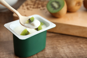 Sticker - Eating of yummy kiwi yogurt from plastic cup on table