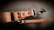© dachux21 - A beautiful brown hand made leather camera sling strap on a black background. Photographer equipment, stylish, vintage, retro feel.