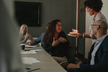 Wall Mural - Coworkers celebrating birthday of female colleague with cake