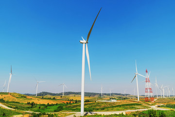 Wall Mural - wind turbines on the hill with blue sky background