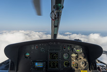 Dashbord of helicopter while flying above the clouds with a moving blade visible