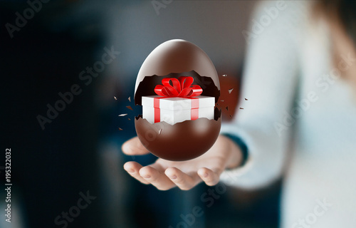 Zdjęcie XXL Czekoladowe jajko z niespodzianką, kobieca ręka, Wielkanoc