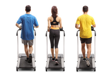 Two young men and a woman exercising on treadmills